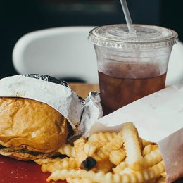 Eine Fast-Food-Essen auf einem Tablett. Schlechte Ernährung führt zu Übergewicht.