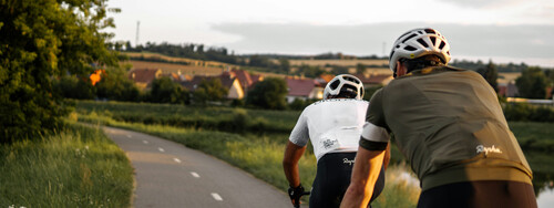 Zwei Rennradfahrer auf einer Landstraße.